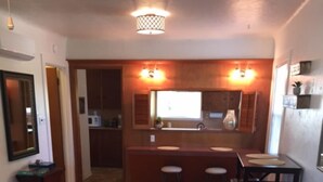 Una sala de estar con un sofá, una mesa de centro y una zona de cocina al fondo.