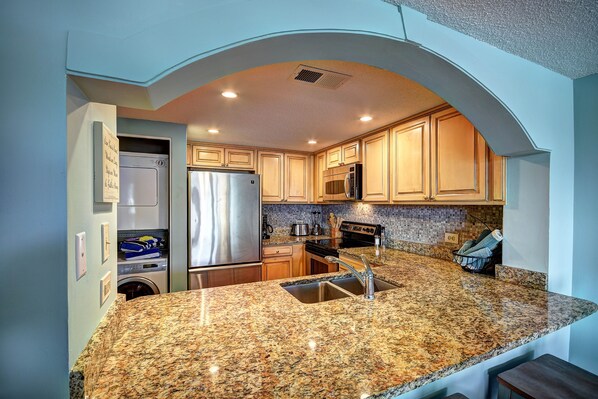 Enjoy cooking in this well-equipped kitchen with a refrigerator, microwave, oven, sink, and dishwasher.