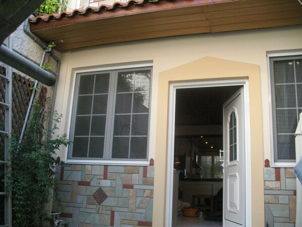 A house with a tiled exterior, a wooden roof, and a large window.