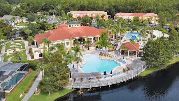 A resort with a swimming pool, multiple buildings, and a dock over water. - Comfortable 4bdr w/private pool - No resort fees (Kissimmee)