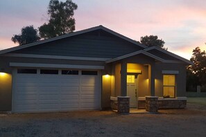 A single-story house with a garage, a front porch with two stone pillars, and a door leading to the interior. - Two Bedroom, clean guest house in Gilbert (Gilbert)