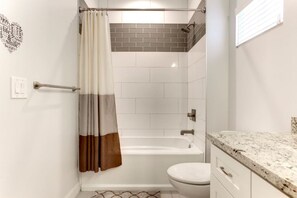 A modern bathroom with a glass-enclosed shower, a white bathtub, and a toilet. - Two Bedroom, clean guest house in Gilbert (Gilbert)