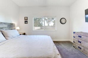 A bedroom with a bed, a dresser, a window, and a wall clock. - Two Bedroom, clean guest house in Gilbert (Gilbert)