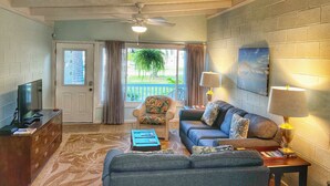 A living room with a sofa, armchairs, a TV, and a ceiling fan. - A Beach, Golf, Tennis and Fun for the whole family Sandy Toes & Salty Kisses A (Jekyll Island)