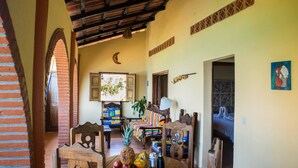 A cozy dining area with a wooden table, chairs, and a mural on the wall. - Oceanfront Yelapa (yelapa)