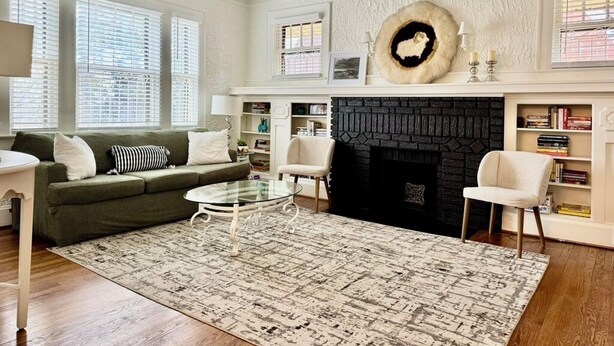 A living room with a fireplace, a ceiling fan, and a round rug. - Beautiful Updated Historic 3BD/2BTH Home (Birmingham)