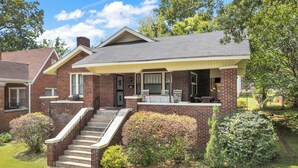 A two-story brick house with a covered porch, a front staircase, and a well-maintained lawn. - Beautiful Updated Historic 3BD/2BTH Home (Birmingham)