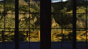 A room with large windows offering a view of a mountainous landscape. - Expansive 6-Bedroom Lodge with gorgeous mountain views. Perfect for large groups (Livingston)