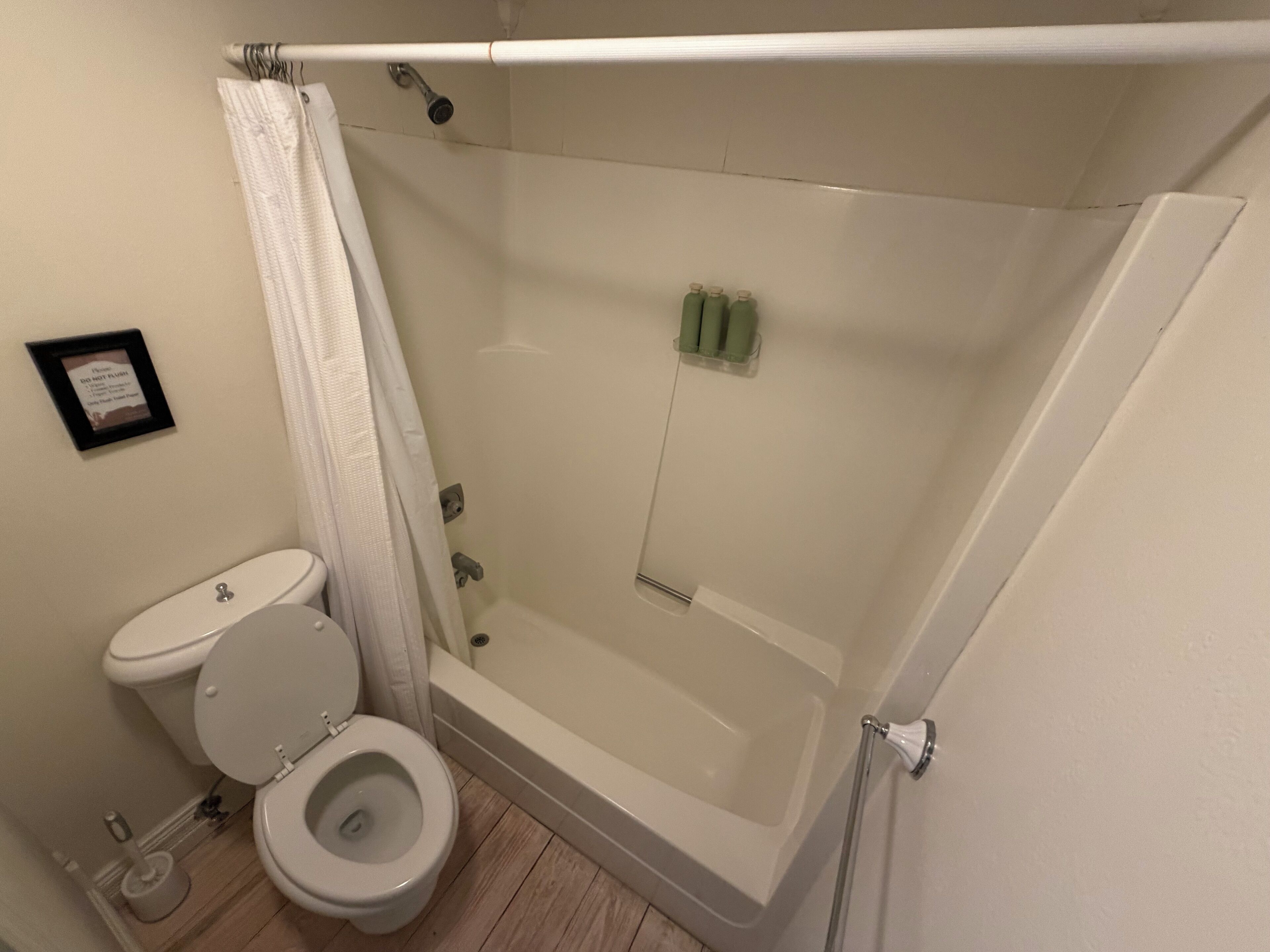 Een badkamer met toilet, douche en bad.