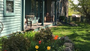 Ein Haus mit einer Steinfassade und einer grünen Veranda.