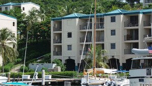 A marina with boats docked, a building with balconies, and lush greenery in the background. - Paradise Found/Breathtaking Views/ Dedicated Wi-Fi
MONTHLY SPECIAL  6/15 - 11/15 (St Thomas)