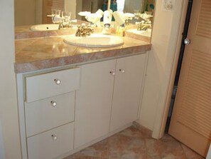 Un baño con dos lavamanos, un espejo y un mueble de tocador con cajones.