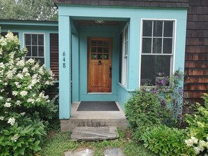 A house with a front porch, a wooden door, and a mailbox.