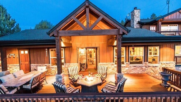 A lodge with a covered patio area featuring a fire pit, outdoor seating, and a stone fireplace. - Bend Country 4 BR/3 Bth, Amazing 9 Mt View, 9 acre, Peaceful Getaway (Terrebonne)