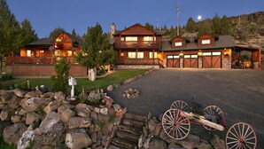 A large, multi-story building with a stone foundation, a driveway, and a horse-drawn carriage. - Bend Country 4 BR/3 Bth, Amazing 9 Mt View, 9 acre, Peaceful Getaway (Terrebonne)