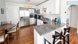 A modern kitchen with white cabinets, granite countertops, a stainless steel refrigerator, and a built-in oven. - Wampler's Lake in Brooklyn, MI close to MIS with access to dock (Brooklyn)