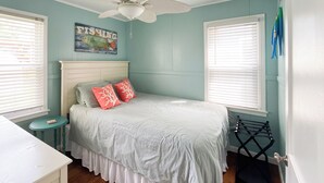 A bedroom with a bed, a ceiling fan, a small table, and a window with blinds. - Wampler's Lake in Brooklyn, MI close to MIS with access to dock (Brooklyn)
