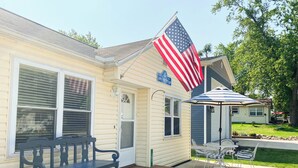 A house with a porch, a bench, an American flag, and a sign that says "EST 2009". - Wampler's Lake in Brooklyn, MI close to MIS with access to dock (Brooklyn)