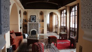 A traditional interior with a fireplace, seating area, and arched doorways.