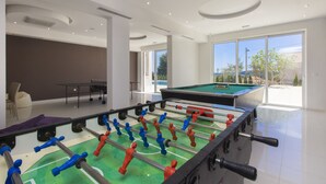 A modern indoor recreational area with a foosball table, pool table, and seating area. - Villa Tramonto (Seget)