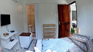 A bedroom with a bed, a TV, a shelf, a wardrobe, and an air conditioner. - Residencial Porto de Galinhas (Ipojuca)