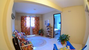A living room with a sofa, a coffee table, and a potted plant. - Residencial Porto de Galinhas (Ipojuca)