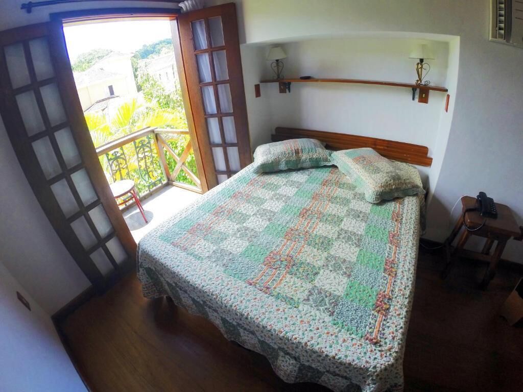 Una camera da letto con un letto, un comodino, una sedia, una finestra e una porta.