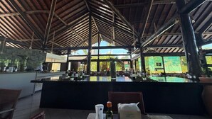 An outdoor bar area with a counter, seating, and a view of the outdoors. - Nannai Residence Apartments - Muro Alto (Porto de Galinhas - PE) (Ipojuca)