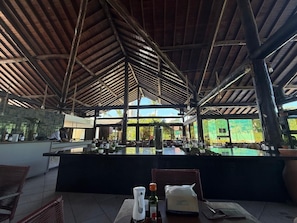 An outdoor bar area with a counter, seating, and a view of the outdoors. - Nannai Residence Apartments - Muro Alto (Porto de Galinhas - PE) (Ipojuca)