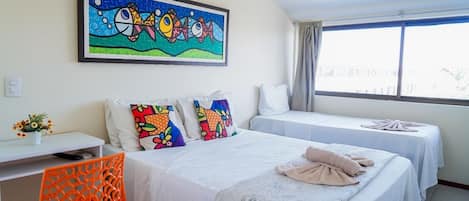 Habitación de hotel con cama, escritorio, silla, ventana y un cuadro en la pared.
