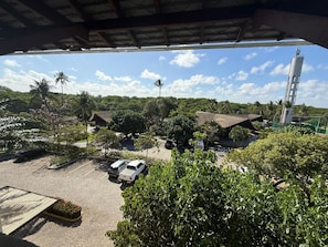 A parking area with several cars, surrounded by lush greenery and a clear sky. - Nannai Residence Apartments - Muro Alto (Porto de Galinhas - PE) (Ipojuca)