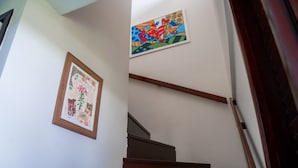 A staircase with wooden handrails and a wall with two framed artworks. - Nannai Residence Apartments - Muro Alto (Porto de Galinhas - PE) (Ipojuca)