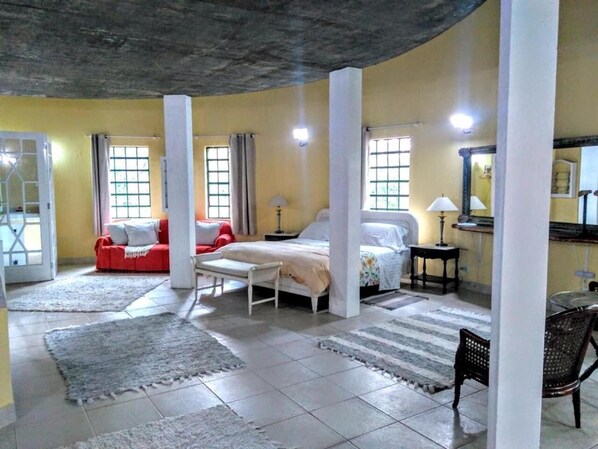 A hotel room with a bed, two sofas, a small table, and a chair. - Villa Serena Bed&Breakfast (Embu das Artes)
