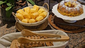 Una mesa de buffet con varios productos horneados y un perro al fondo.