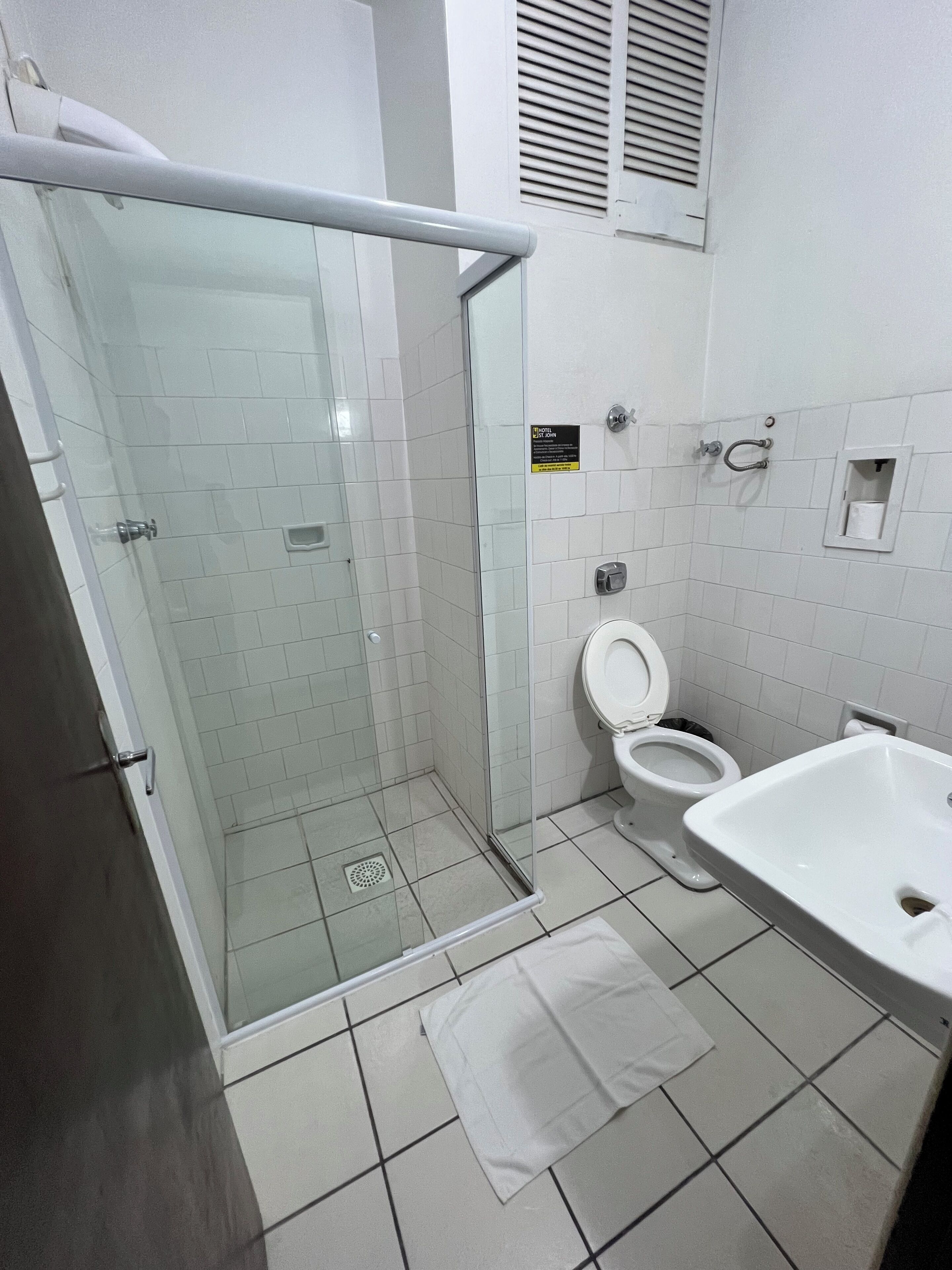 Un baño moderno con ducha envuelta en vidrio, inodoro y lavamanos.