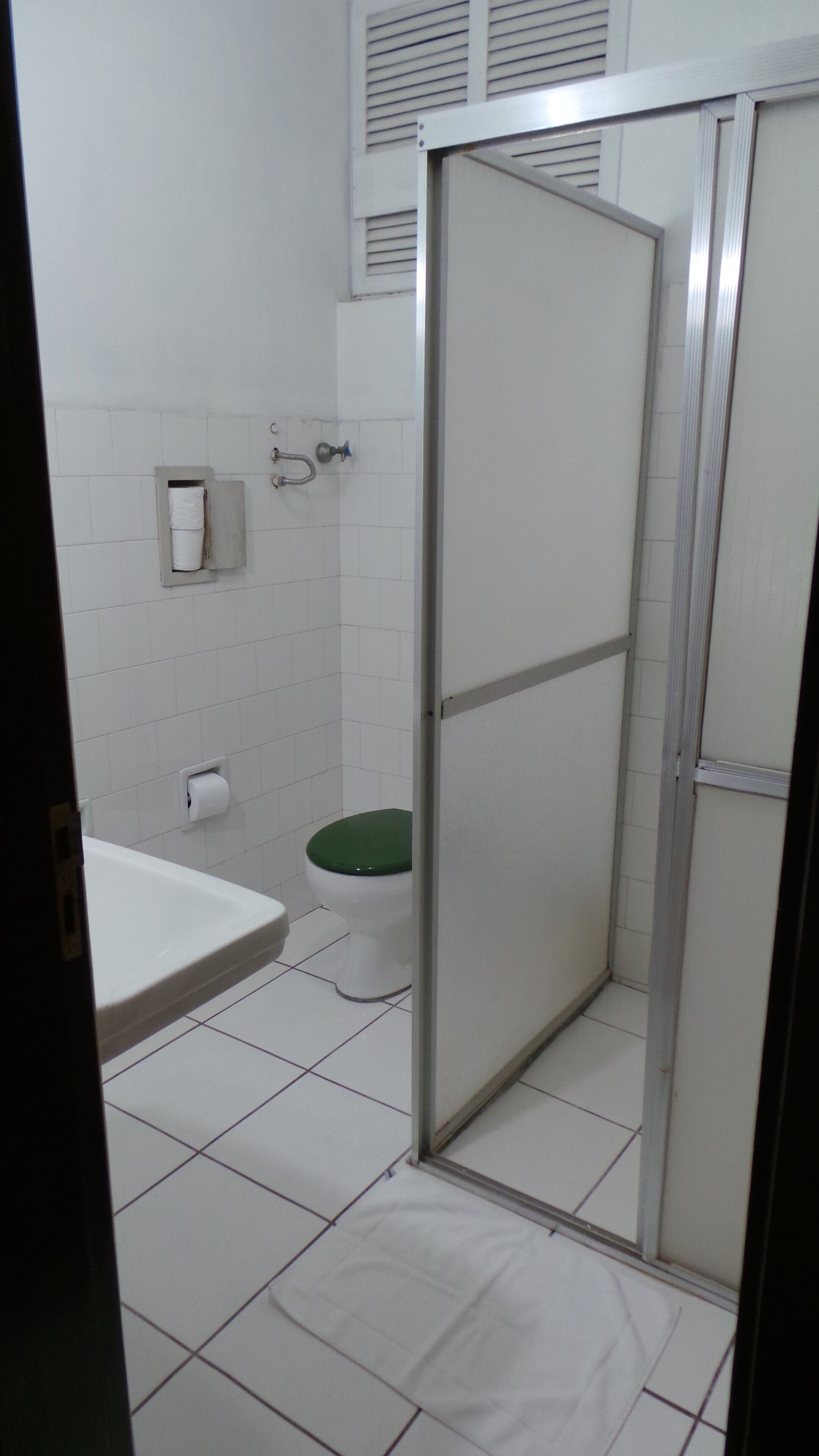 Un baño con inodoro, cabina de ducha y lavamanos.