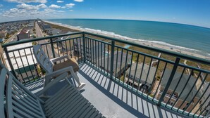 Un balcon avec vue sur la plage et l’océan.