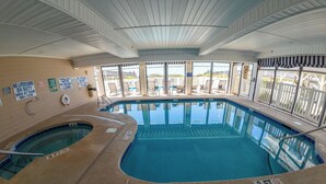 Une piscine intérieure dotée de panneaux d’avertissement clairs, d’une indication de profondeur de 3 pieds et offrant une vue sur la plage grâce à de grandes fenêtres.