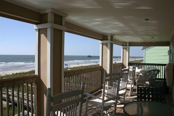 Relax in this oceanfront space with a round table and comfortable seating.
