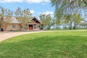 A house with a sloped roof, a front porch, and a well-maintained lawn.