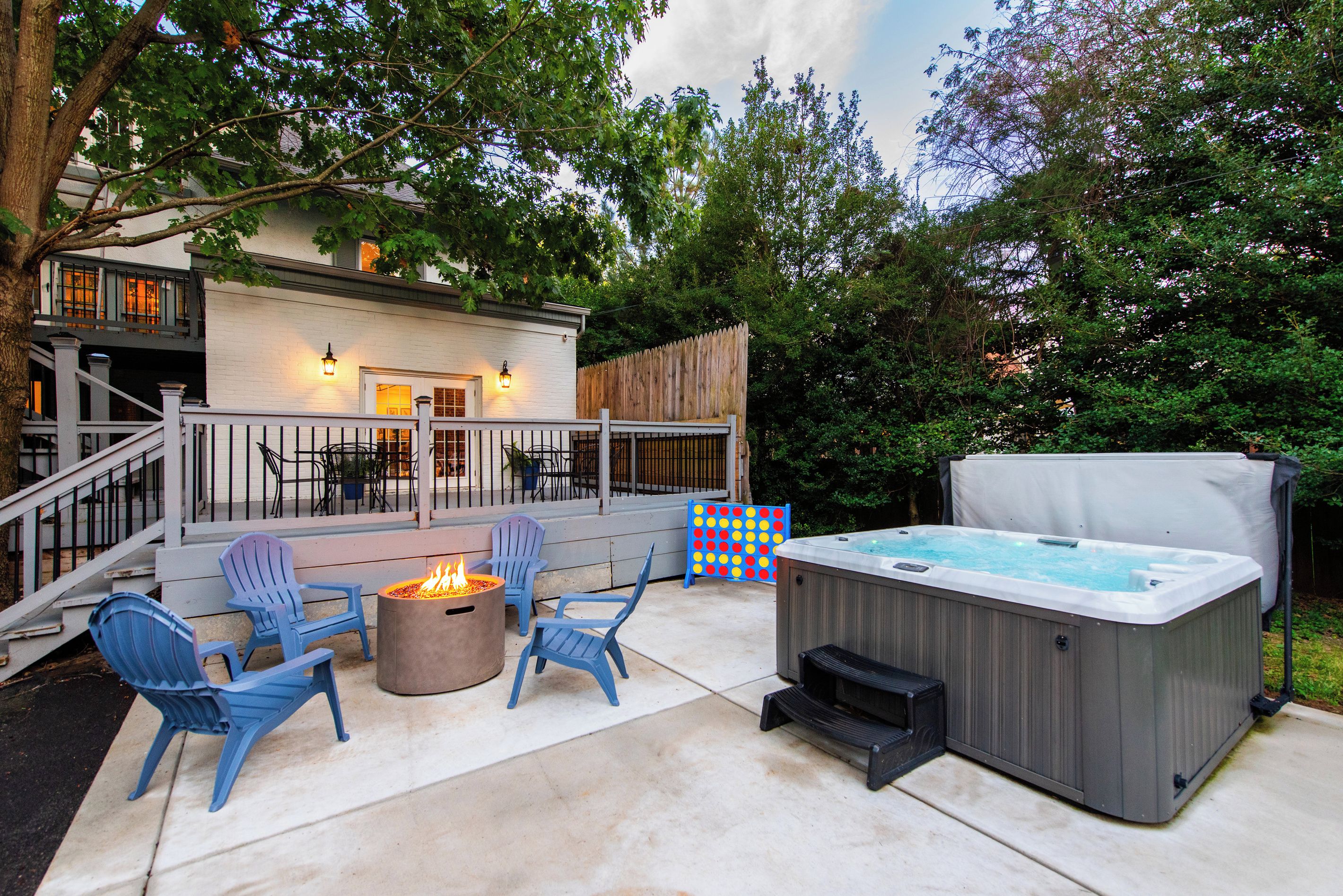 An outdoor patio area with a hot tub, fire pit, and seating.