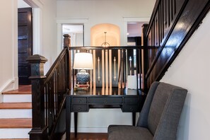 A staircase with a dark wooden railing and a desk with drawers in the middle.