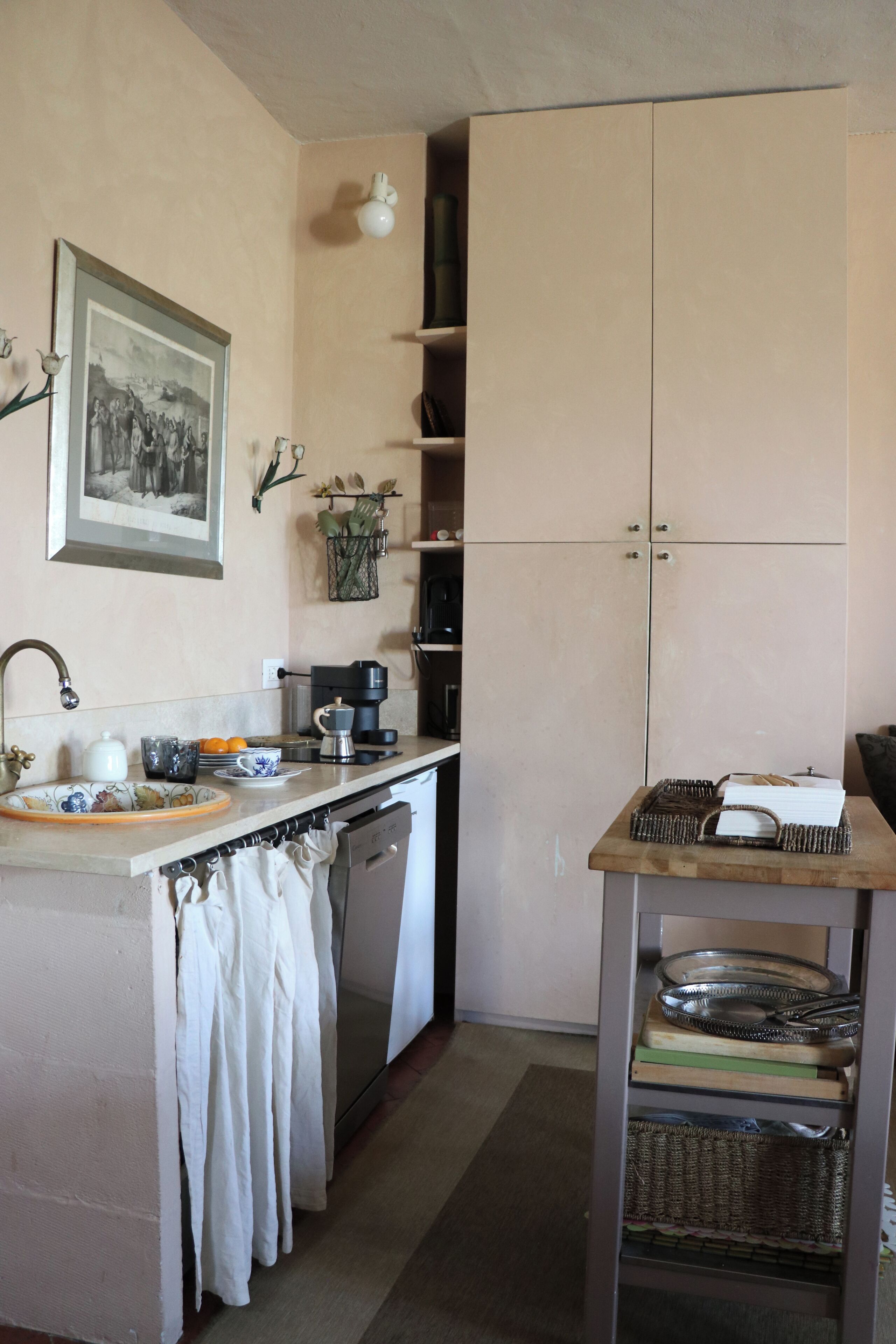 A compact kitchen with a sink, coffee maker, and a small dining area with a table and chairs.