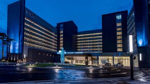 A modern hotel with a prominent illuminated sign, a well-lit entrance, and a spacious parking area. - Lotte Resort Sokcho (Sokcho)