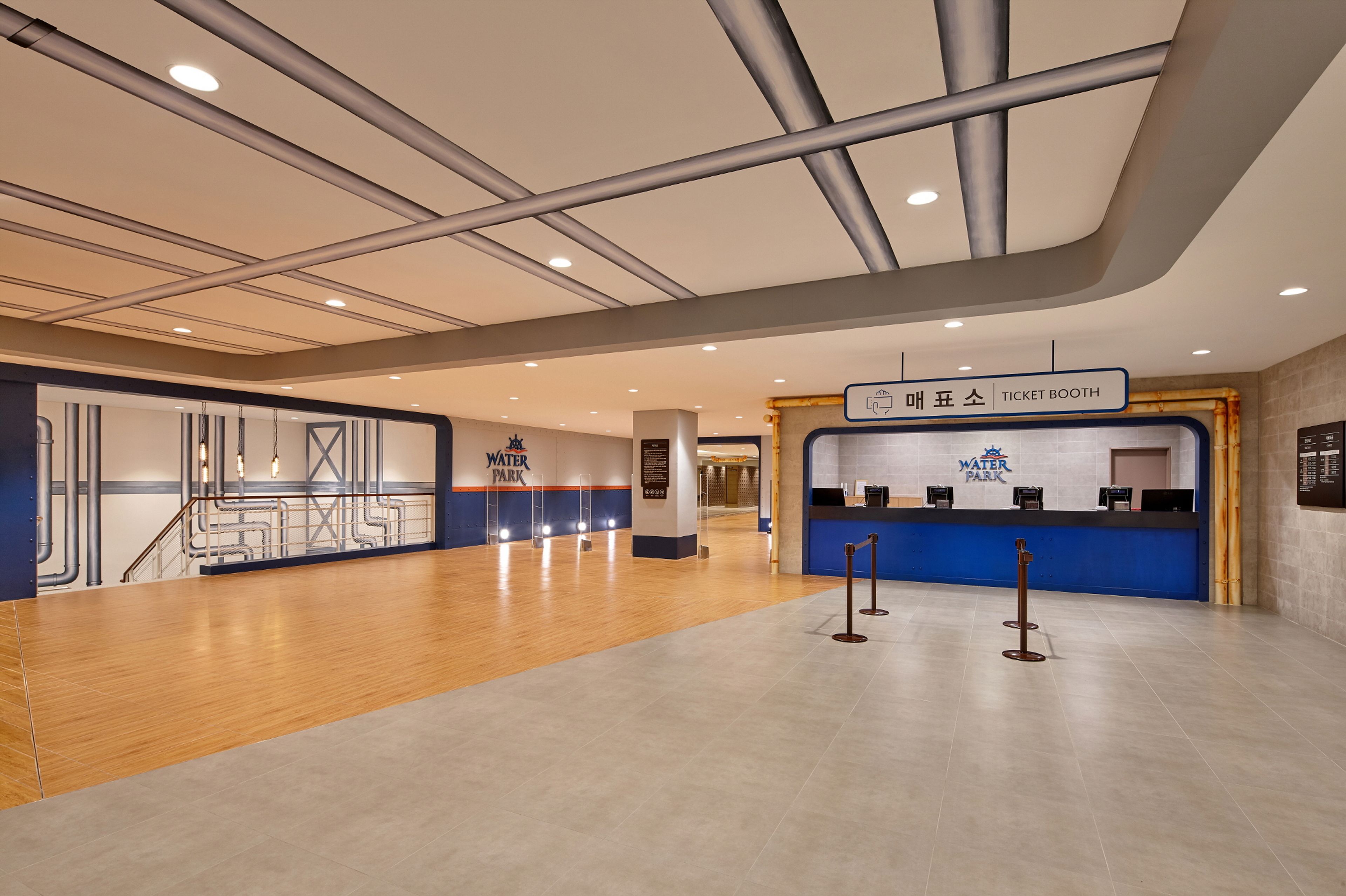 En rummelig lobby med en billetbod, en trappe og et skilt med teksten 'Water Park'.