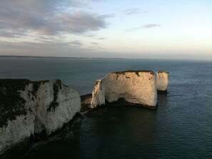 A coastal scene with white cliffs and calm sea.