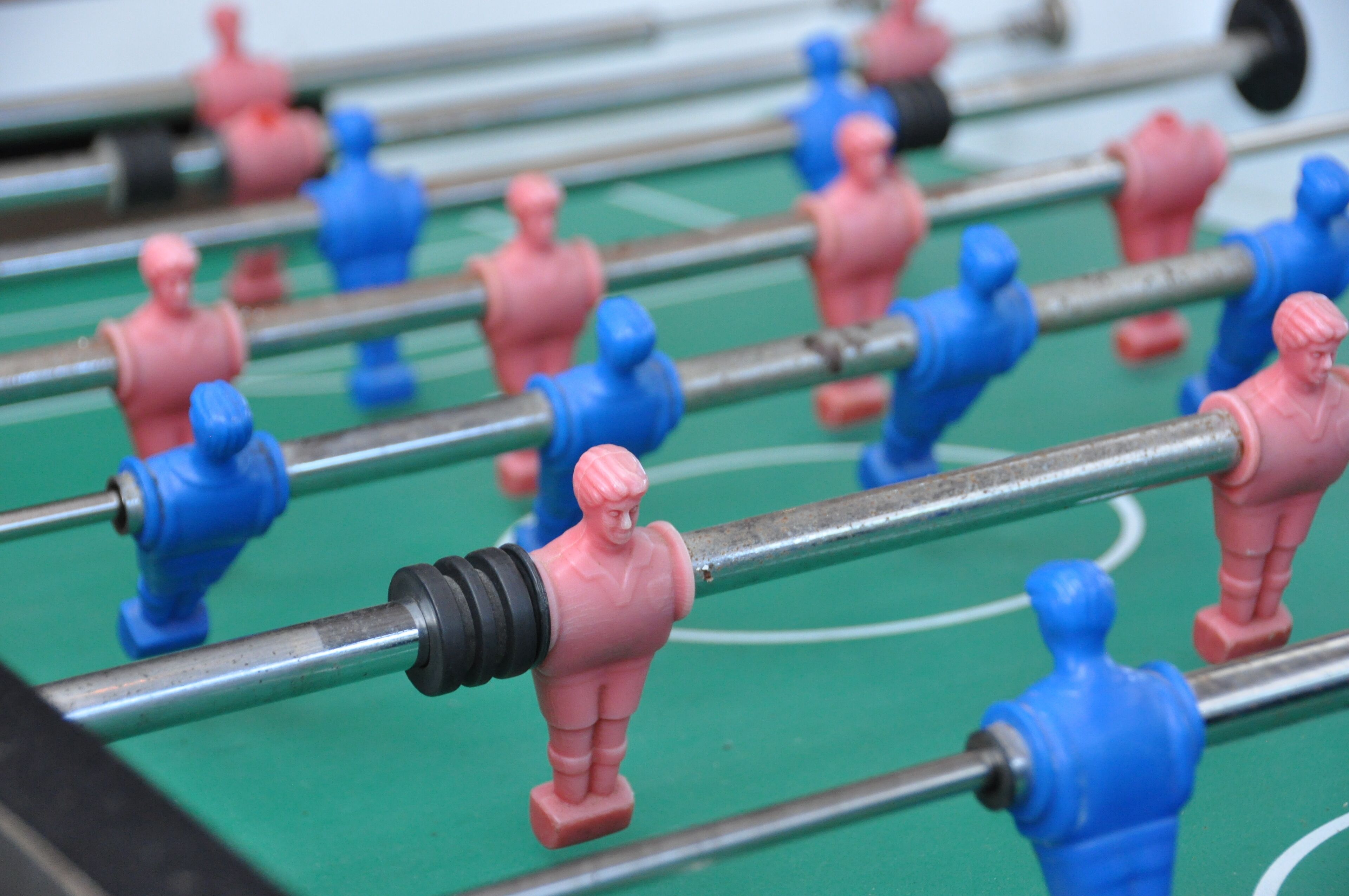 Close-up de uma mesa de futebol de mesa com peças vermelhas e azuis.