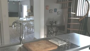 A modern kitchen with a built-in sink, wooden cutting board, and a Frigidaire refrigerator. - Renovated stone house private next to river, Welcoming and very well equipped (Juvinas)