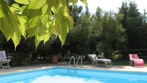 A swimming pool with lounge chairs and a wooden deck.