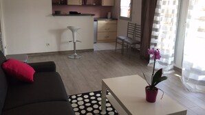 Ett modernt vardagsrum med en soffa, ett soffbord och en matplats med en stol och ett bord.